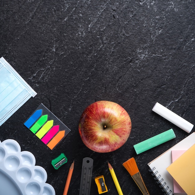 Back to school student design concept, top view of stationery over slate black table background with copy space.