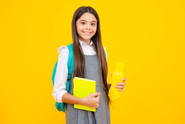 Back to school student teenager girl with water bottle and holding books and note books wearing backpack