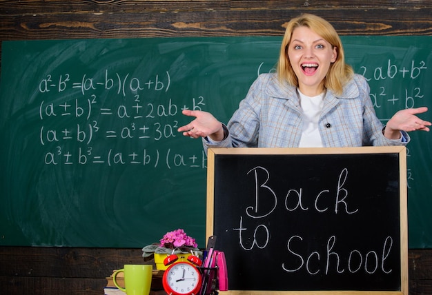 Back to school. Teachers day. Study and education. Modern school. Knowledge day. woman in classroom. School. Home schooling. happy woman. teacher with alarm clock at blackboard. Time. Amazing story.