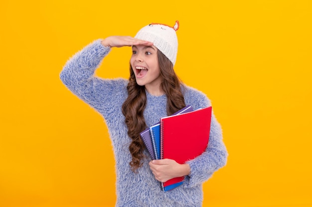 Back to school teen girl in knitwear on yellow background