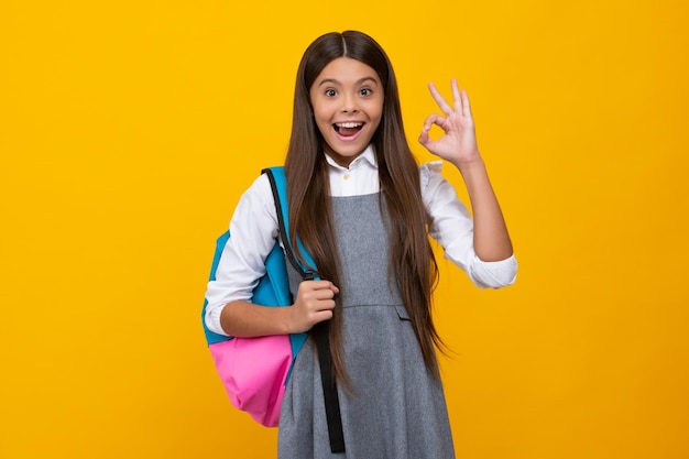 Back to school Teenage school girl ready to learn School children on yellow isolated background Excited face cheerful emotions of teenager girl