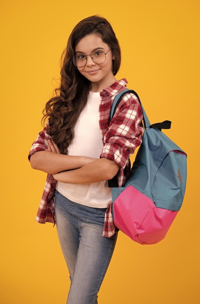 Back to school Teenage school girl ready to learn School children on yellow isolated background Happy teenager positive and smiling emotions of teen girl