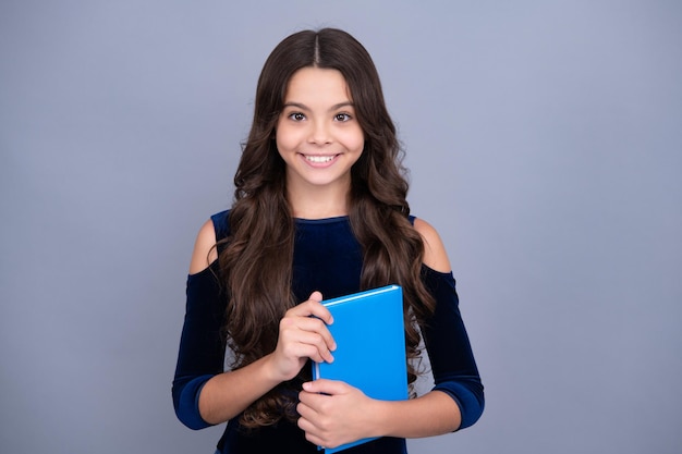 Back to school Teenager schoolgirl hold book and copybook ready to learn School children on isolated grey background Happy face positive and smiling emotions of teenager girl