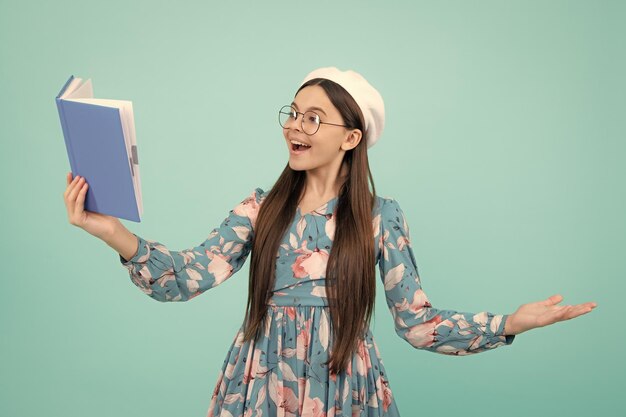 Back to school Teenager schoolgirl with book ready to learn School girl children on isolated blue studio background Excited teenager amazed and cheerful emotions