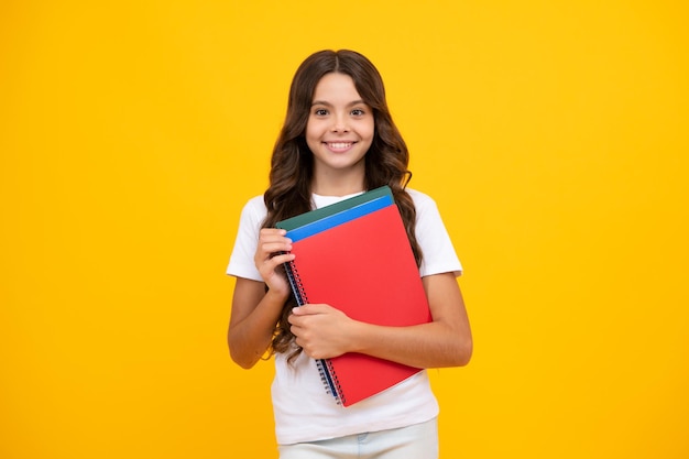 Back to school teenager schoolgirl with book ready to learn school girl children on isolated yellow studio background