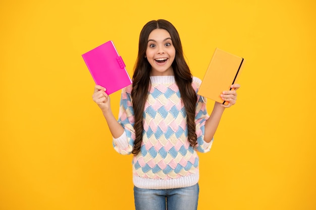 Back to school Teenager schoolgirl with book ready to learn School girl children on isolated yellow studio background