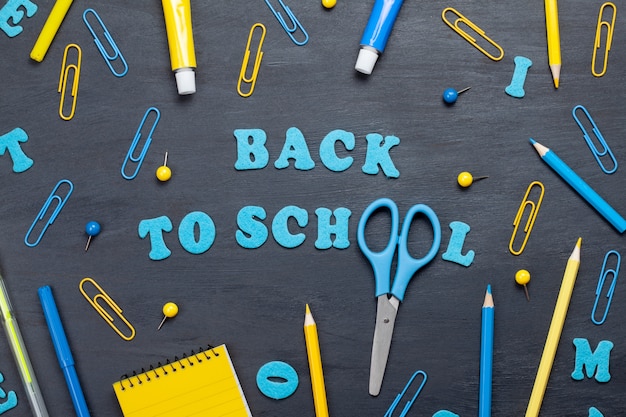 Back to school text with colorful stationary over the blackboard