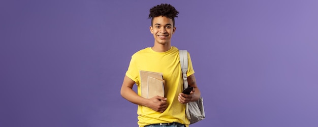 Back to school university concept portrait of young cheerful male student with dreads hipster going