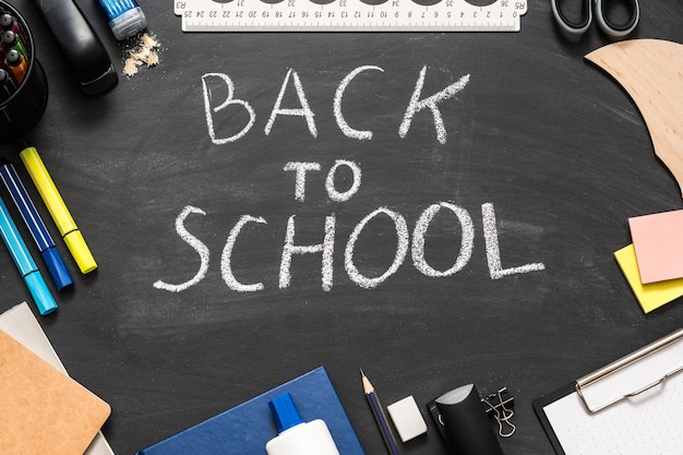 Ritorno a scuola in gesso bianco con scritte sulla lavagna nera.
