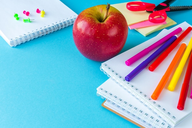 Back at school, work, workplace of a schoolchild stationery, notebooks on blue 