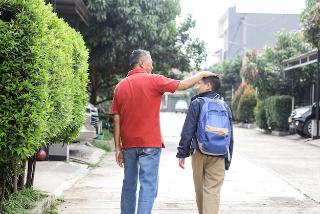 写真 学校に通いながら孫の頭を撫でる祖父の裏側子育てと家族活動