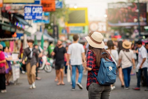 KhaosanRoadを歩いて見ている若いアジア人旅行女性の裏側