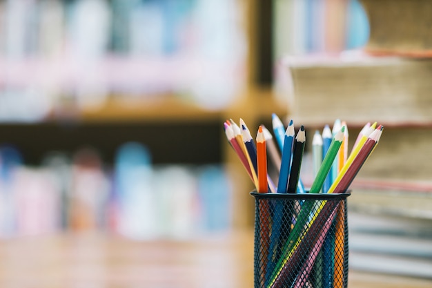 写真 ソフトフォーカスにバスケットに木製の色鉛筆で学校の背景に戻る。教室や図書館で