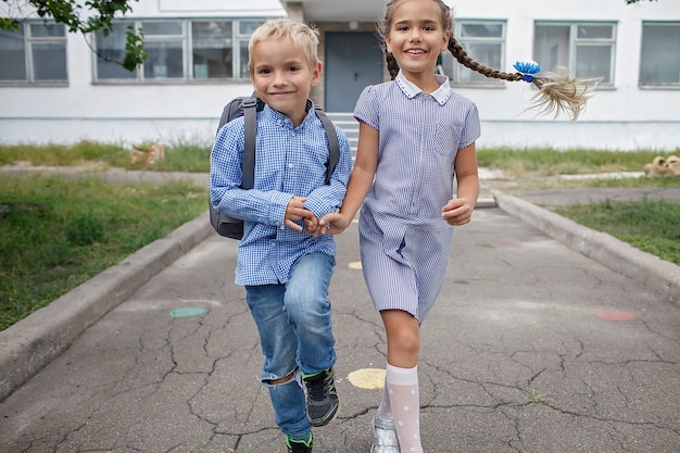 Фото Снова в школу братья и сестры с рюкзаками убегают из школы после первого дня офлайн.