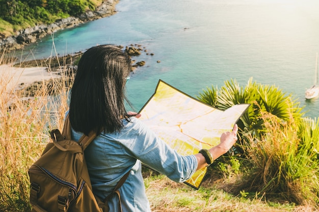 Indietro della ragazza del viaggiatore con lo zaino guardando la direzione