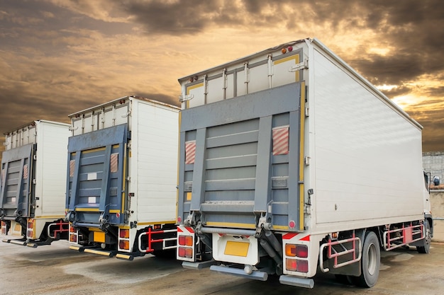 Back of the trucks container with hydraulic lift parking at warehouse, freight industry logistics and transport