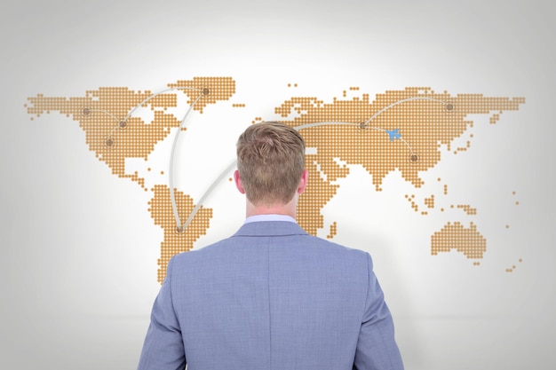 A back turned businessman on a background against world map with lines