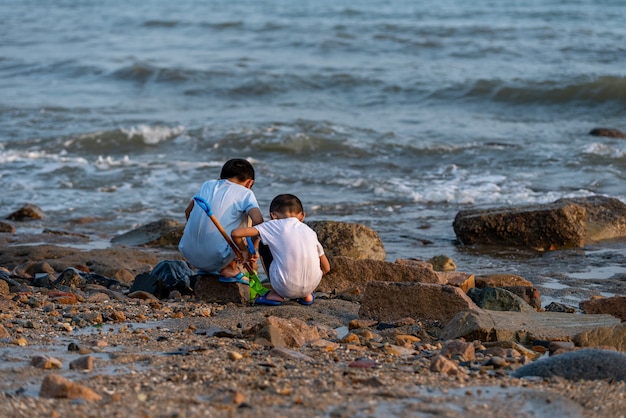 The back of two children playing upstream of the beach.