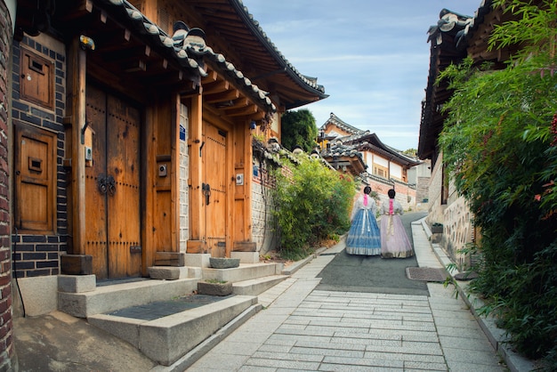 Back of two woman wearing hanbok walking in Bukchon Hanok Village in Seoul, South Korea.