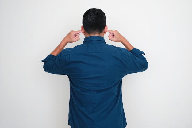 Photo back view of adult man closing his ears with fingers