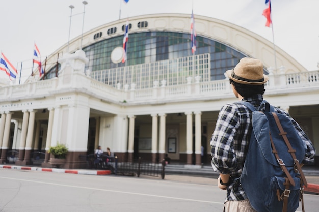 Back view Asian man bag pack tourist in railway station at Thailand.