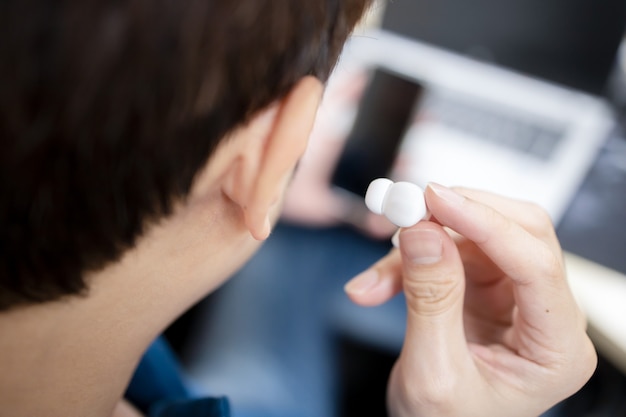 Back View of Asian Man Hold Wireless Earbud Ready to Use With Smart Phone