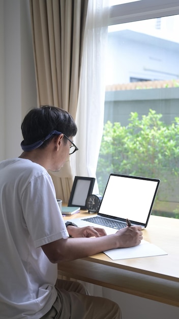 Back view asian man surfing internet in living room