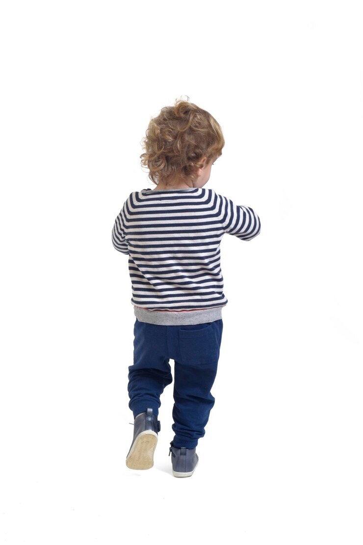 白い背景の上を歩く男の子の背面図