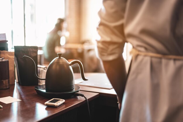 La vista posteriore del barista nel bancone del bar presso la caffetteria. caffè, barista, bar, caffè, profondo, macchina, concetto di stile di vita.