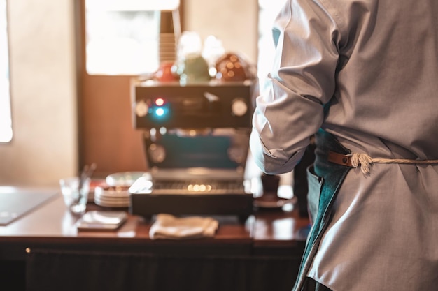 La vista posteriore del barista nel bancone del bar presso la caffetteria. caffè, barista, bar, caffè, profondo, macchina, concetto di stile di vita.