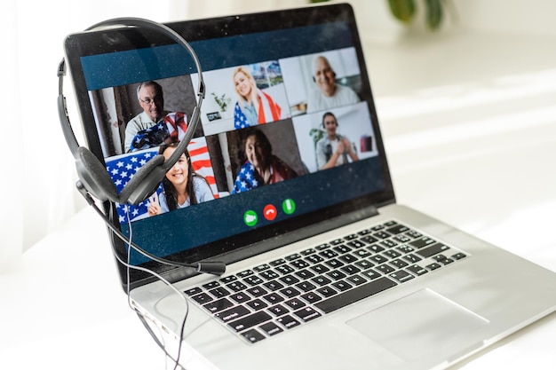 Back view of business woman talking to her colleagues in video conference business team using laptop for a online meeting in video call working from home in America.