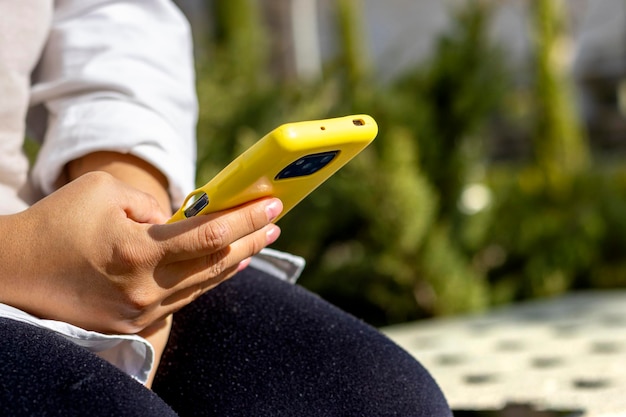 Вид сзади крупным планом женской руки с помощью смартфона