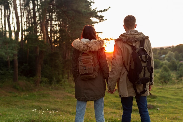 Back view couple enjoying sunrise in the nature