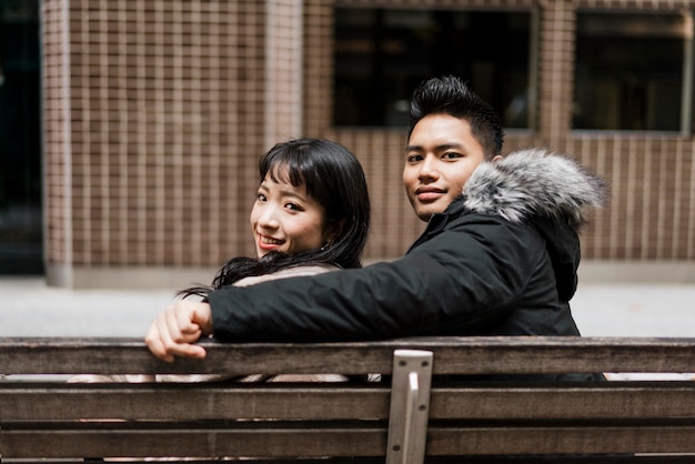 Photo back view of couple sitting together on a bench