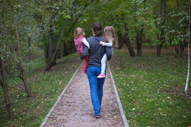 Back view of father and his two little daughters outdoor