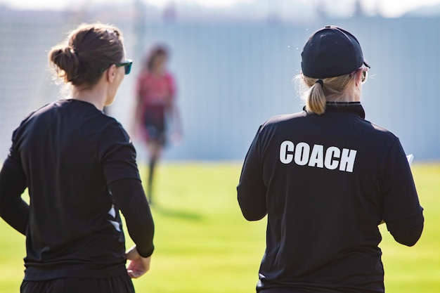 Vista posteriore della vettura sportiva femminile e il suo assistente in camicia nera coach