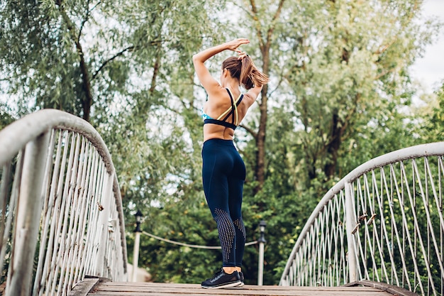 Photo back view of girl correct hair on wooden bridge