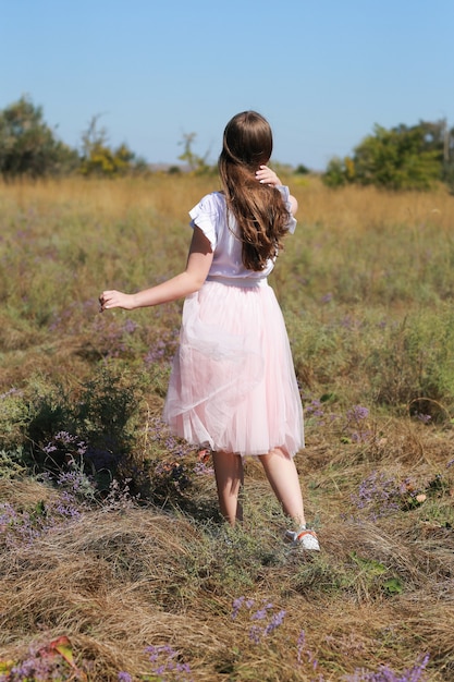 Back view of girl  on flower meadow