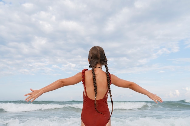 Photo back view girl having fun at the beach