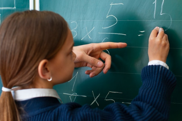 Back view girl learning math at school