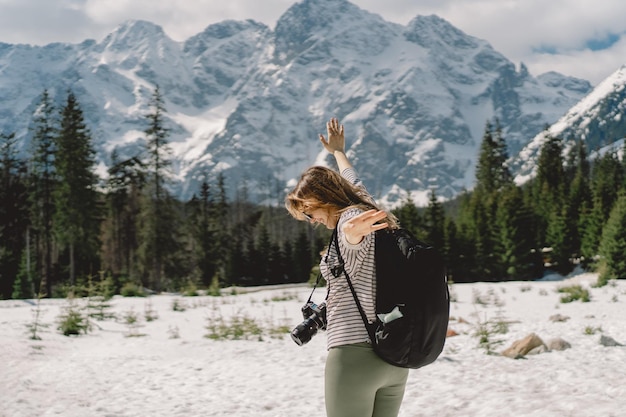 Back view of a girl traveler wearing a backpack traveling alone in the valley of the Tatra mountains in the country of Poland