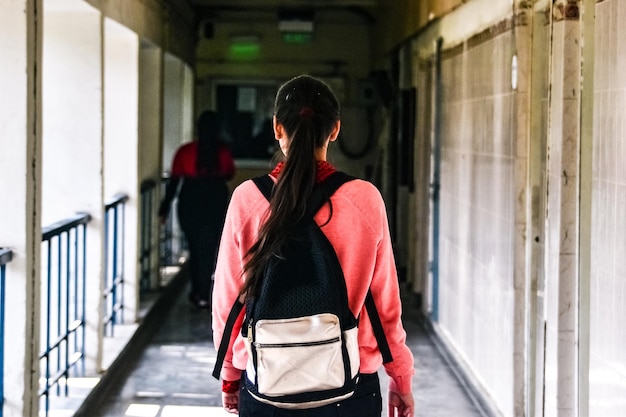 Photo back-view of a girl walking in corridor