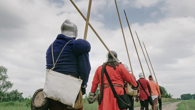 Back view of group medieval knights going on the battle.