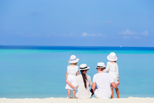 Vista posteriore di una famiglia felice sulla spiaggia tropicale