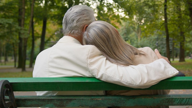 写真 バックビュー幸せな可愛い灰色の ⁇ の高齢夫婦がベンチに座って話し合い,抱きしめる街を議論しています