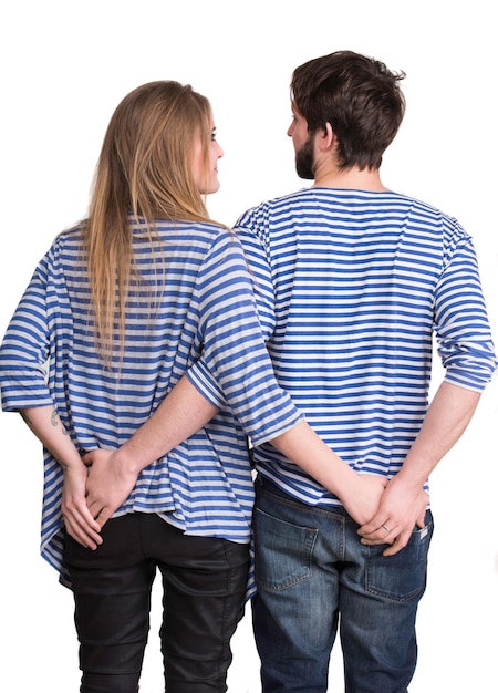 Back view of hugging young couple on a white background