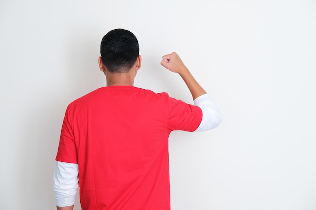 Photo back view on indonesian man clenched fist during independence day celebration