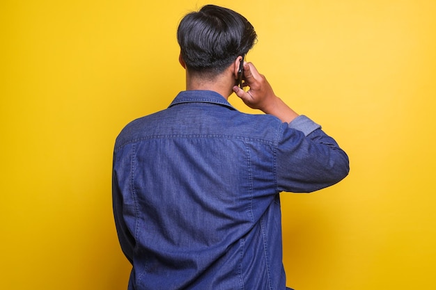 Вид сзади человека, отвечающего на звонок мобильного телефона