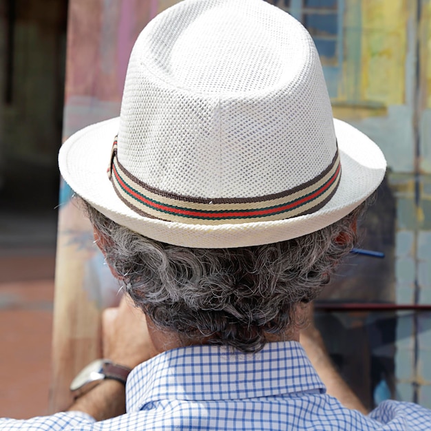 Back view of a man artist painting in the street