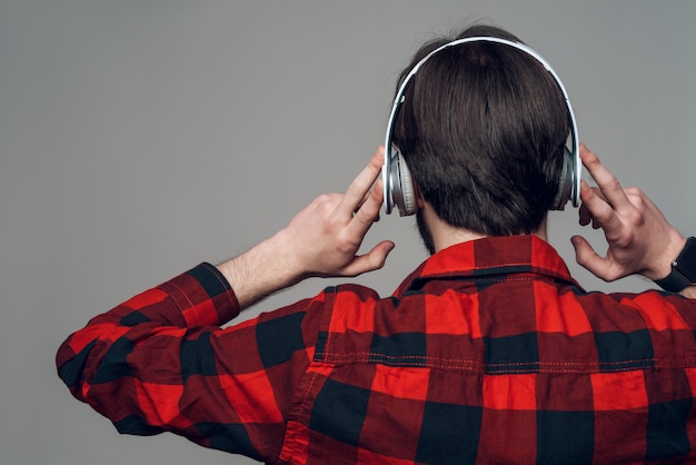 Back view. Man listening to music with headphones